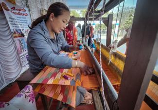 Kunsthandwerk gehört zu Nepals Exportgütern: Hier webt Anfang 2023 eine Frau einen Schal auf einer Messe in Kathmandu. 