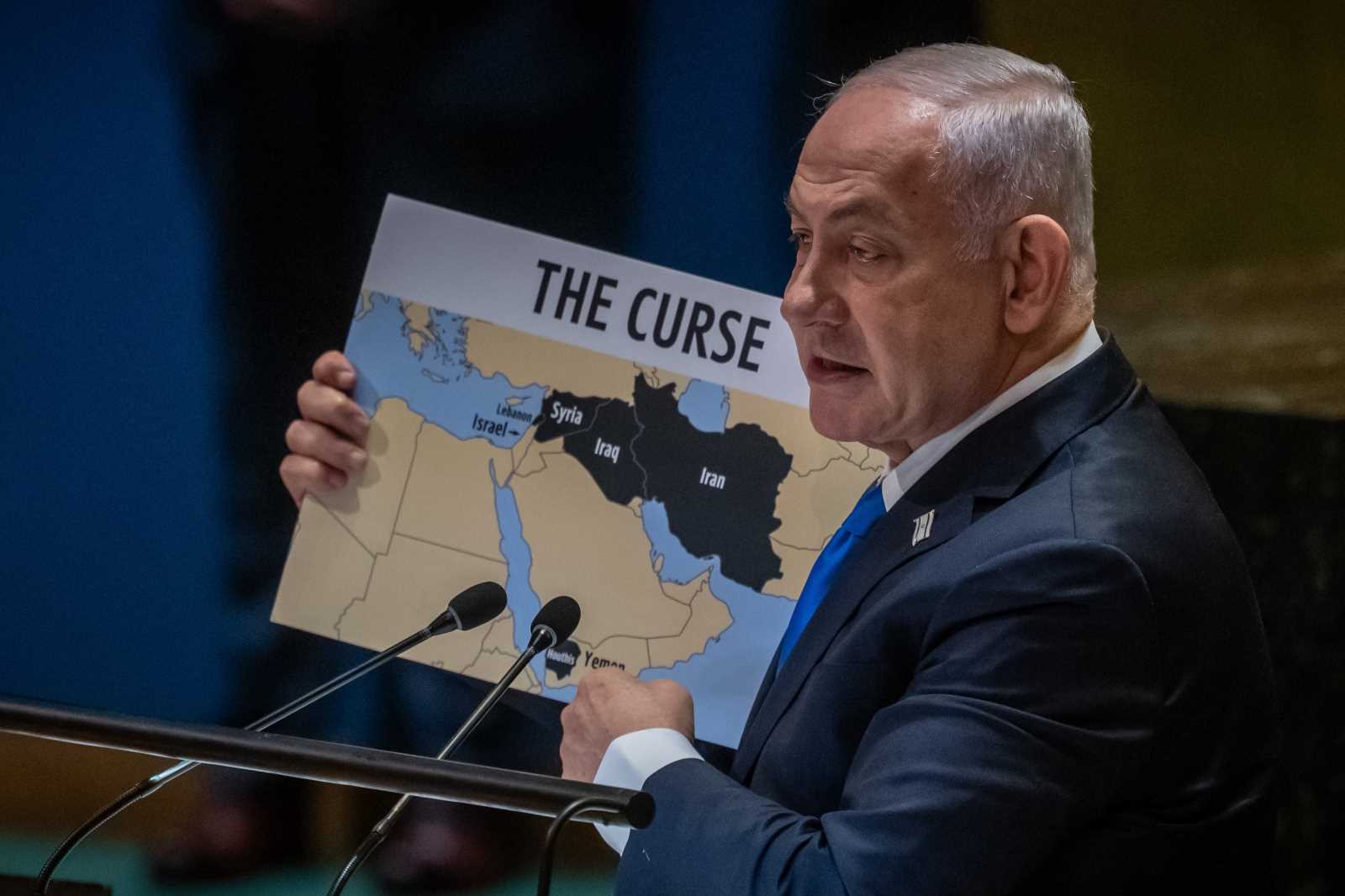 Benjamin Netanyahu addresses the UN General Assembly in September 2023, holding a map of the Middle East that shows the West Bank and Gaza as part of Israel.
