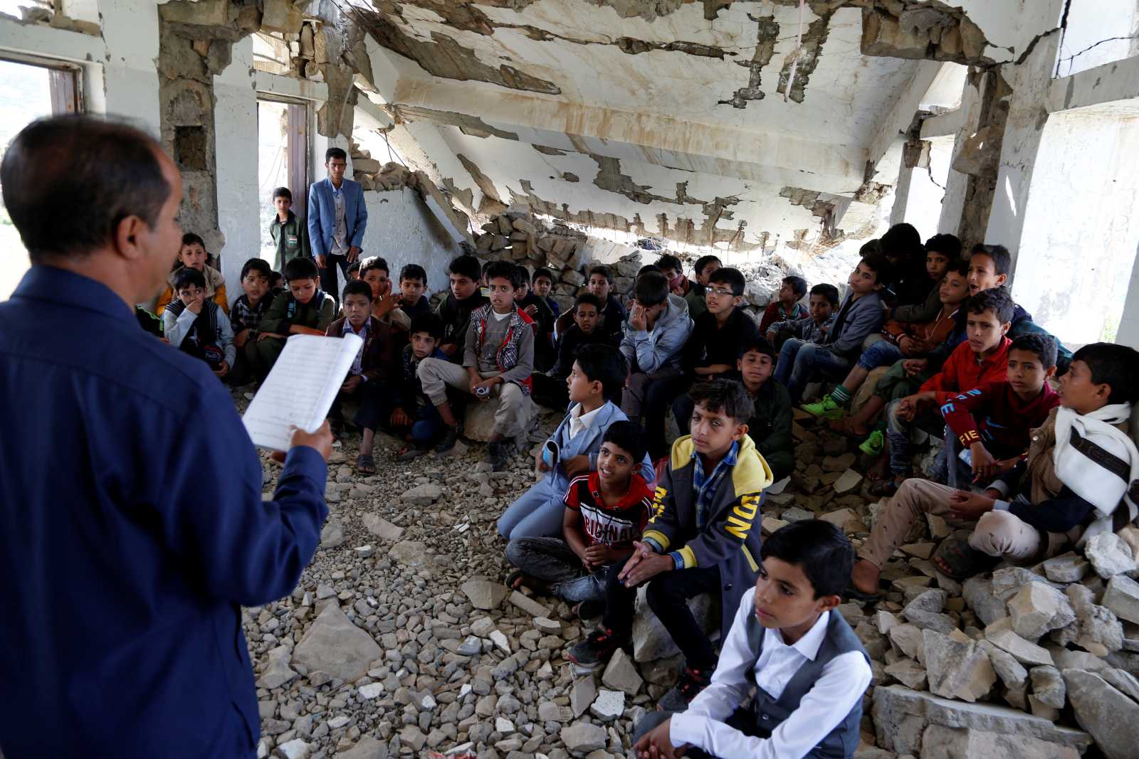 Students being taught inside a half-collapsed building at Shuhada-Alwahdah School in Ibb province, Yemen.