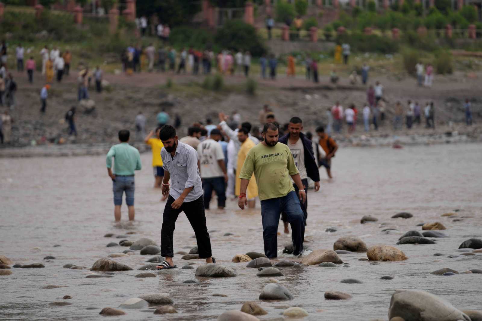 People cross the Chenab River after the flow of water was halted from a dam, at Akhnoor, on the outskirts of Jammu, India in May. 