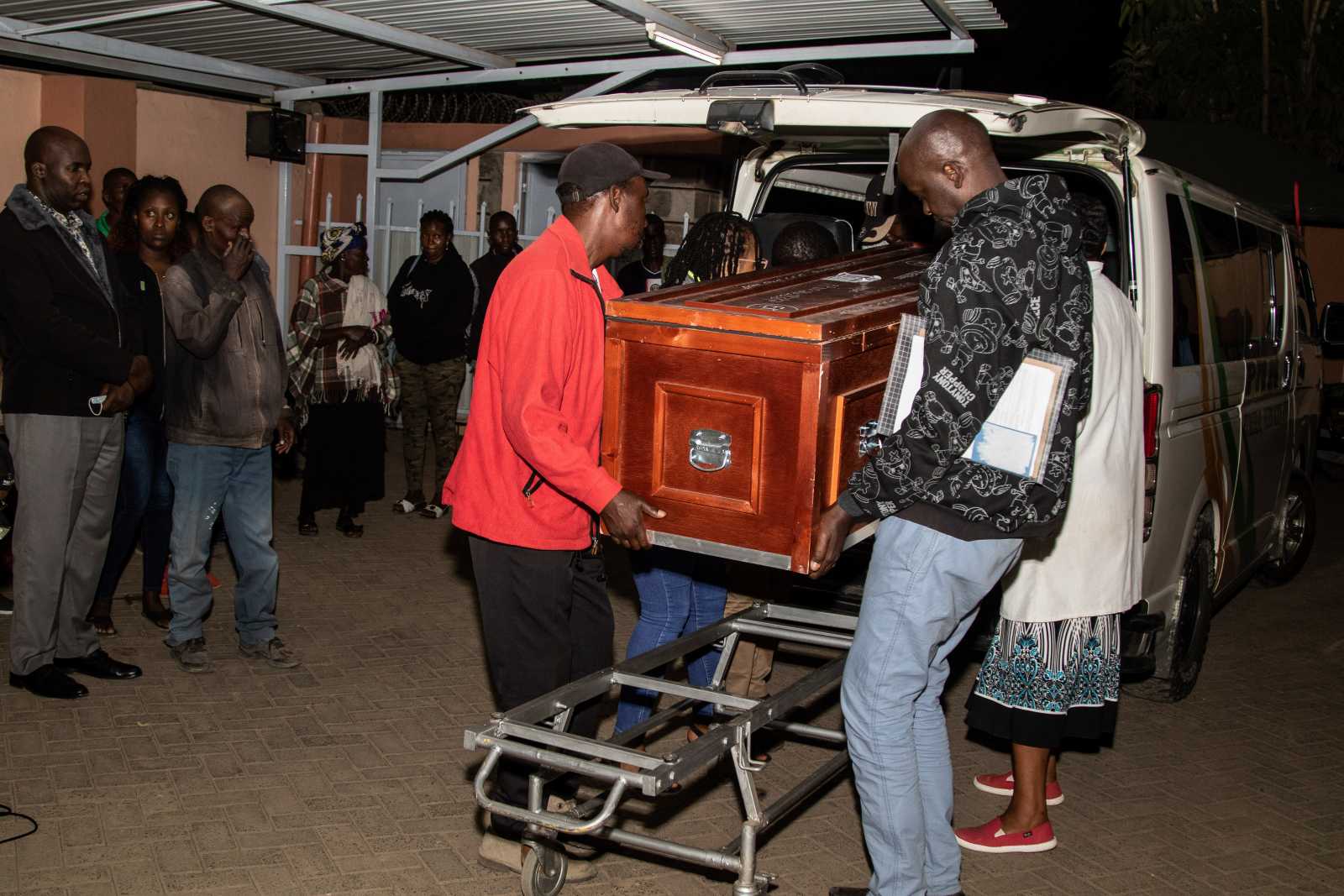 The body of a Kenyan domestic worker who died under unclear circumstances in Saudi Arabia is carried out of a hearse in Kenya in 2023.