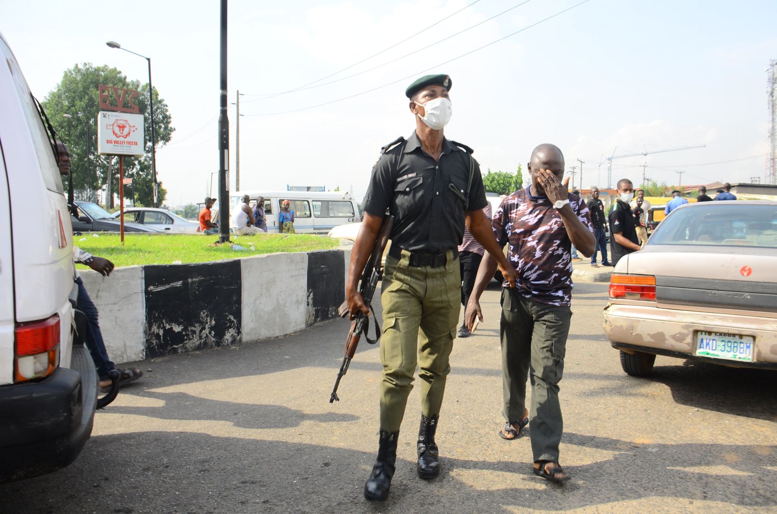 Nigerian police officer arresting man for disobeying lockdown.