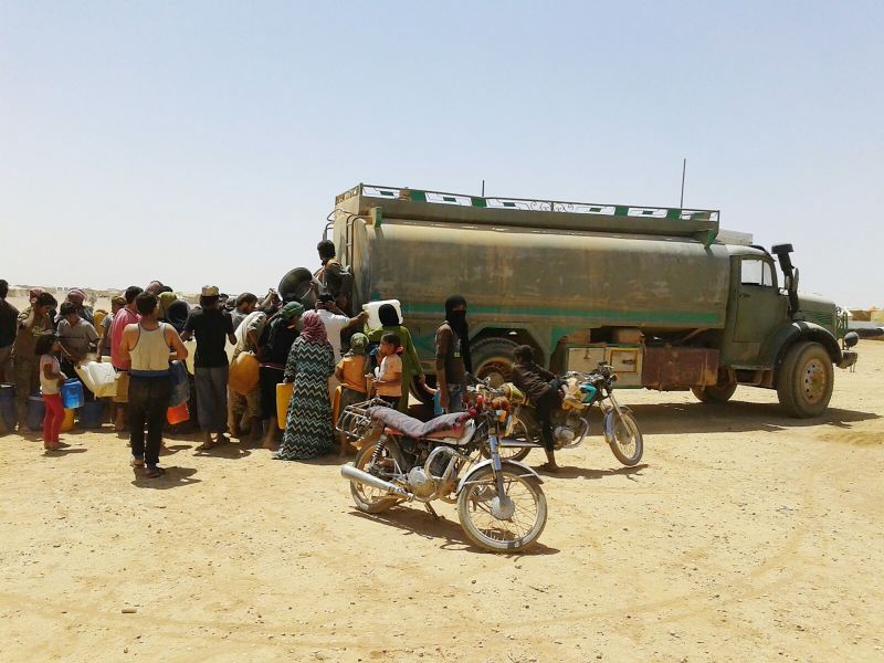 Syrian refugees standing in line to get water in Jordanian camp in June 2016.