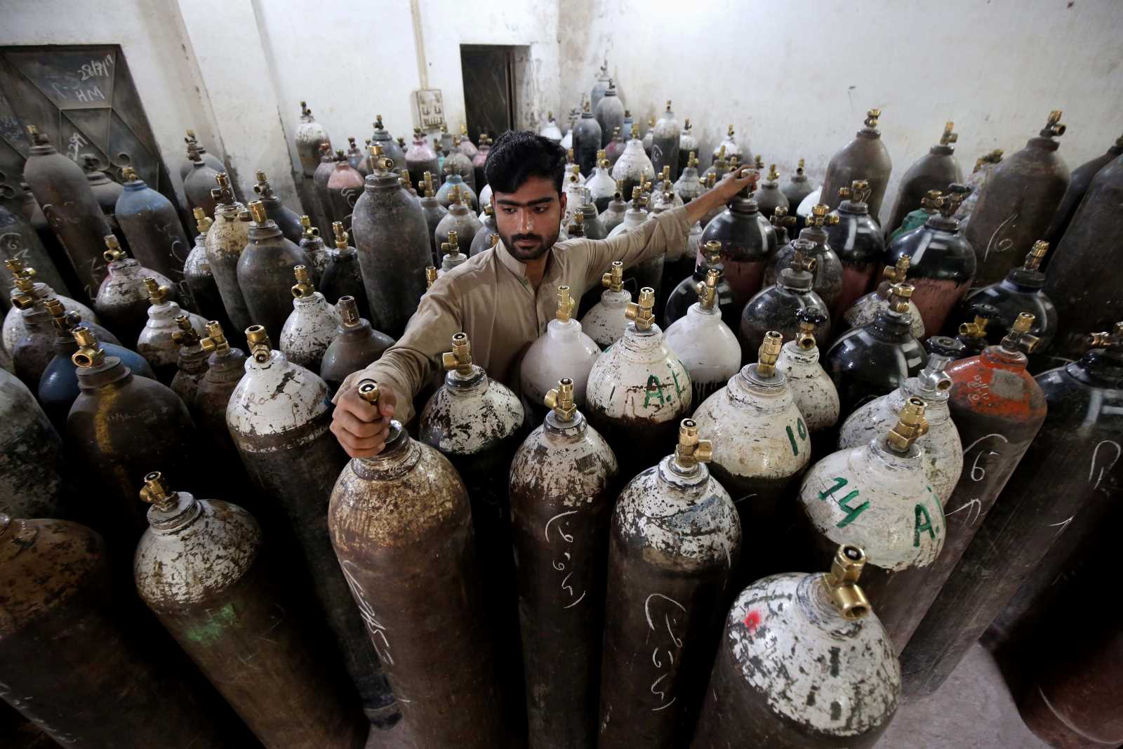 A man in Pakistan refills oxygen cylinders as demand for oxygen supplies rose due to Covid-19 patients in Peshawar, in 2021.