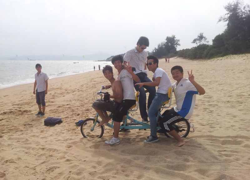 Young men enjoying a bicycle ride on the beach in the low-carbon city of Xiamen in South-West China. China is recently experiencing a bicycle and outdoor activity boom.
