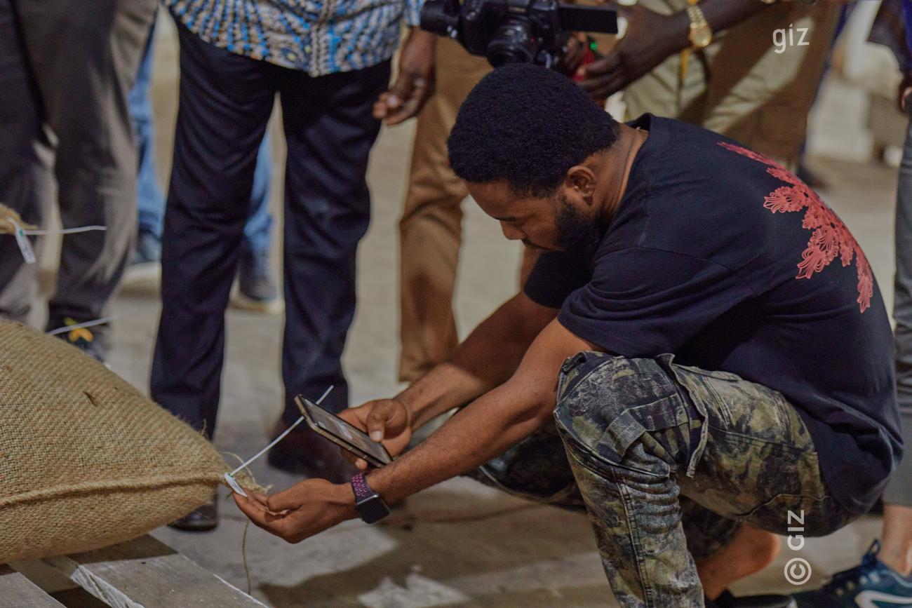 A man is screening a code on a sack with his smartphone