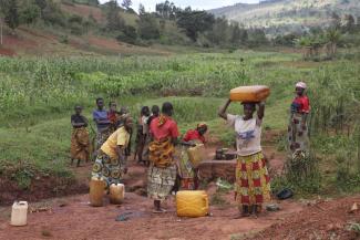 The chrores of Burundian farm women include fetching water.