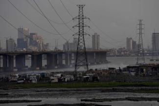 Power lines and bridges in Lagos, Nigeria: infrastructure matters – and national governments need money to rise to the responsibility. 