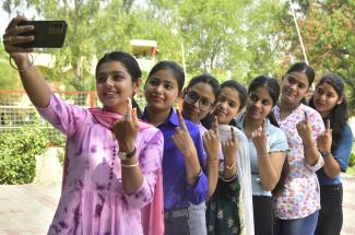 Young women show their inked fingers after casting their votes during parliamentary elections in India in June.