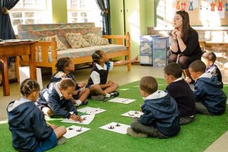 Young woman in Pädagogikstudentin der südafrikanischen Universität Stellenbosch unterrichtet 2015 Grundschulkinder. traing at Stellenbosch University, South Africa, in 2015.