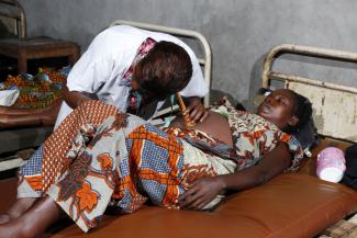 Underfunded health-care systems: a doctor examining a pregnant woman in Congo-Brazzaville long before the pandemic.