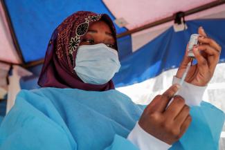 Kenyan nurse preparing an AstraZeneca shot in January 2022.