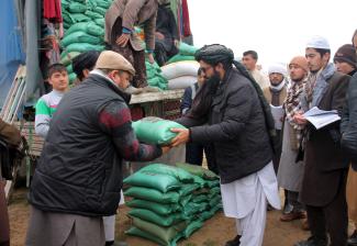 Afghans receive assistance donated by an aid agency in Jawzjan province, northern Afghanistan, January 2022.