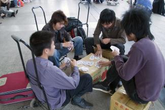 Binnenmigranten vor dem Bahnhof von Guanzhou, China.