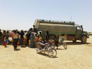 Syrian refugees standing in line to get water in Jordanian camp in June 2016.