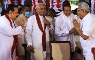 picture-alliance/NurPhoto/Tharaka Basnayaka Regierung als Familienangelegenheit: Premierminister Mahinda Rajapaksa (links) begrüßt Präsident Gotabaya Rajapaksa (rechts) mit einem weiteren Bruder, Chamal Rajapaksa (der jetzt als Minister für Bewässerung fungiert), bei einer offiziellen Zeremonie im August 2020.