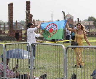 Während einer Gedenkfeier in Auschwitz, Polen, zeigen Menschen eine Roma-Flagge zur Erinnerung an die Roma und Sinti, die im Zweiten Weltkrieg von Nazi-Deutschland getötet wurden.