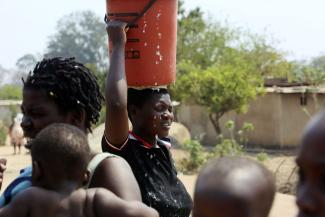 Eine Frau in Harare, der Hauptstadt Simbabwes, bringt Wasser nach Hause.