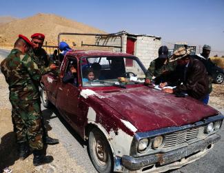 Syrian soldiers checking papers of retournees from Lebanon at the border crossing in Zamrani.