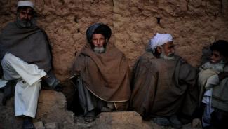 Afghan refugees sit outside their homes in Islamabad.