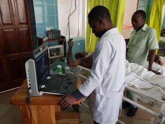 Doctor Henry Marique Mwigani performs an ultrasound examination on a trauma patient.