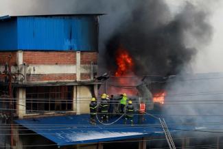 picture alliance / REUTERS / Navesh Chitrakar Firefighters at burning biscuit factory in August 2021.
