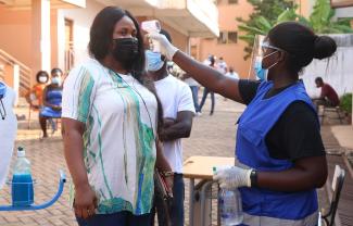 The pandemic is slowing down economic life: taking a person’s temperature in Accra, Ghana.